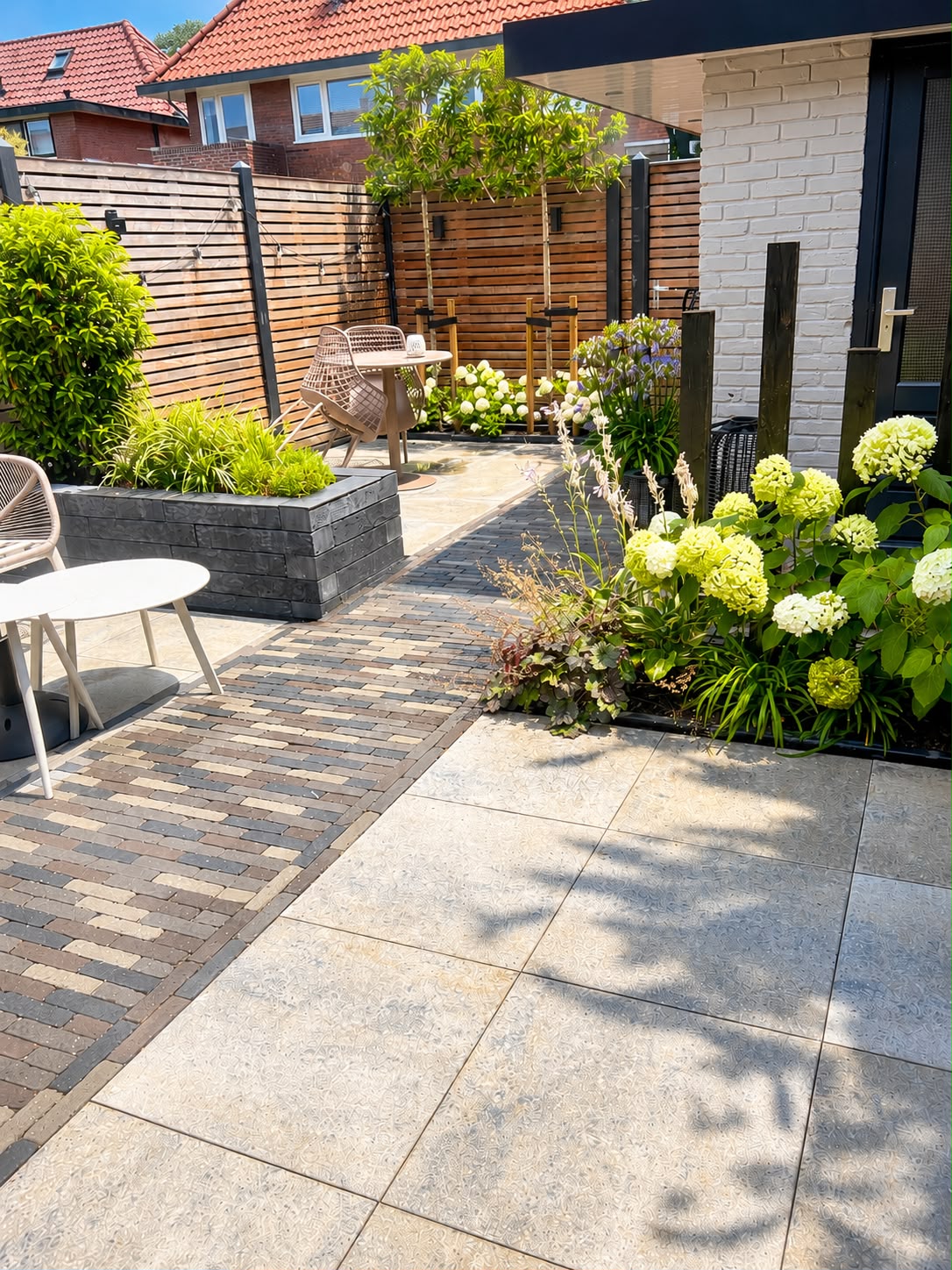 Aangelegde tuin met natuursteen terras en beplanting door JP Buitenbeheer